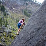 man climbing on rock mountain