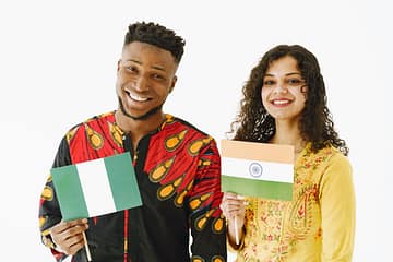 smiling young man and woman holding their country flags