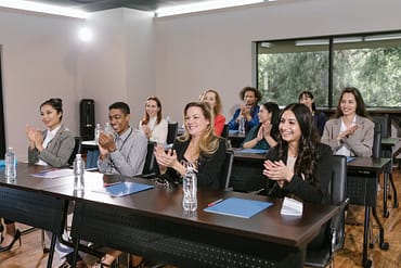 group of people in a conference room clapping