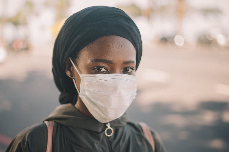 black female in medical mask on street
